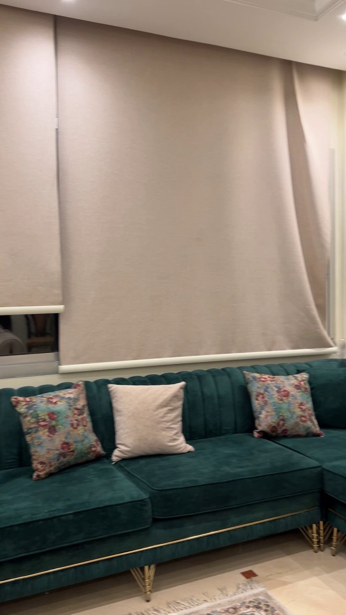 A single frame extracted from the source video: a living room with a teal sofa
